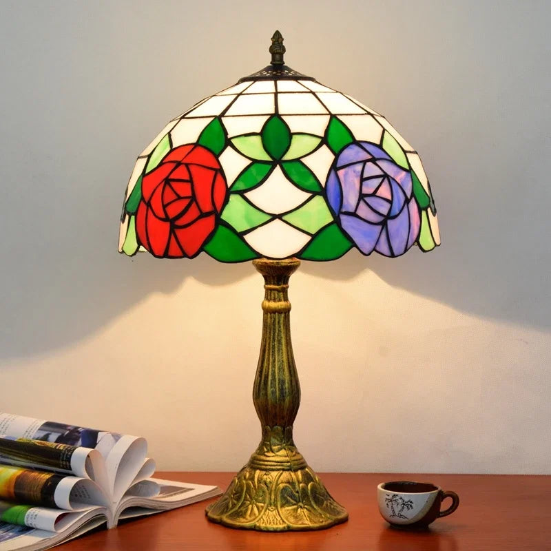 Lampada da tavolo Tiffany con vetri colorati e rose rosse e viola.