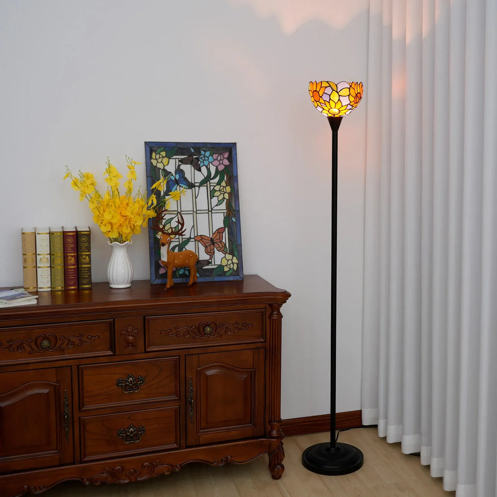 Lampada da terra Tiffany con motivi floreali in vetro giallo e arancione.