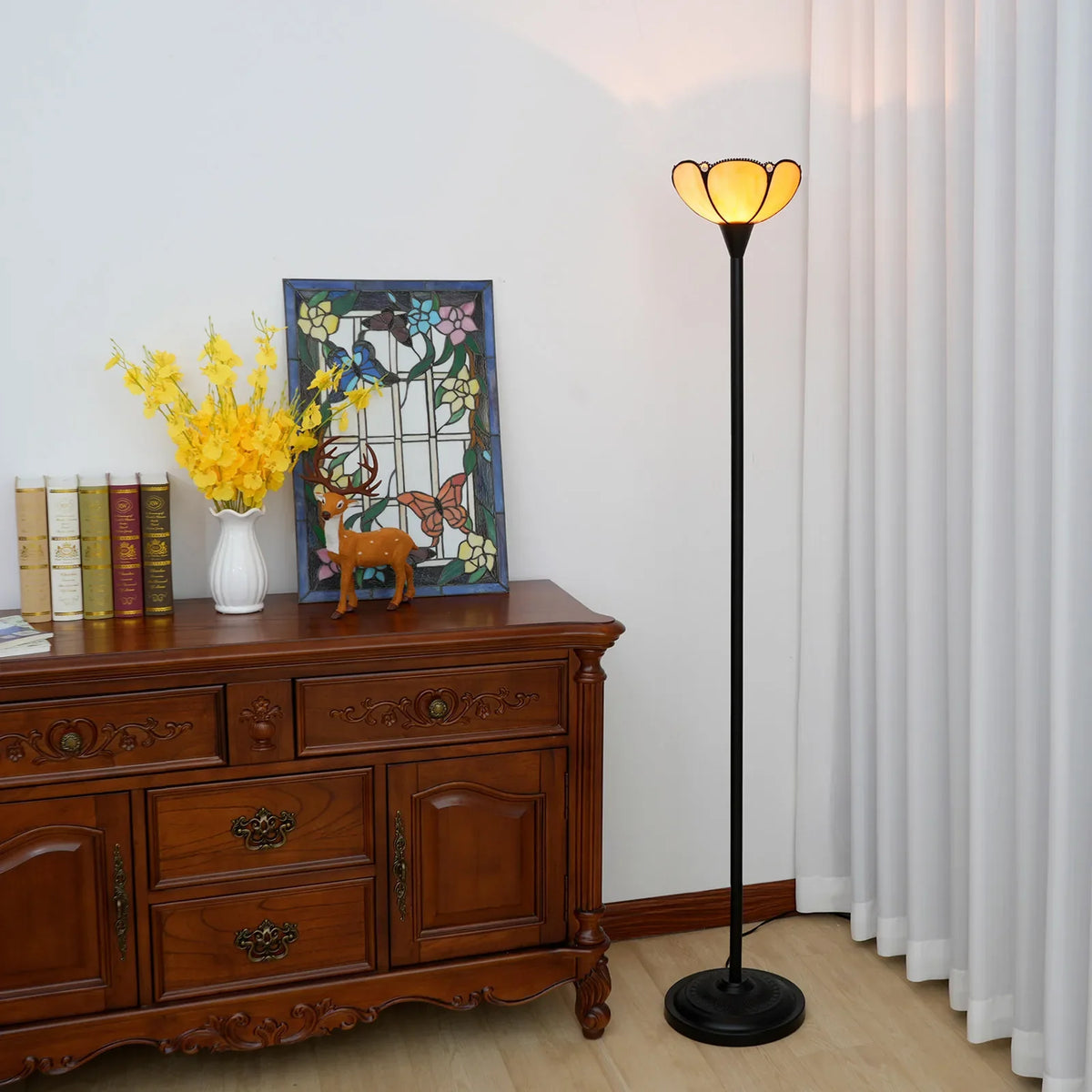 Lampada da terra con paralume floreale in vetro ambrato.