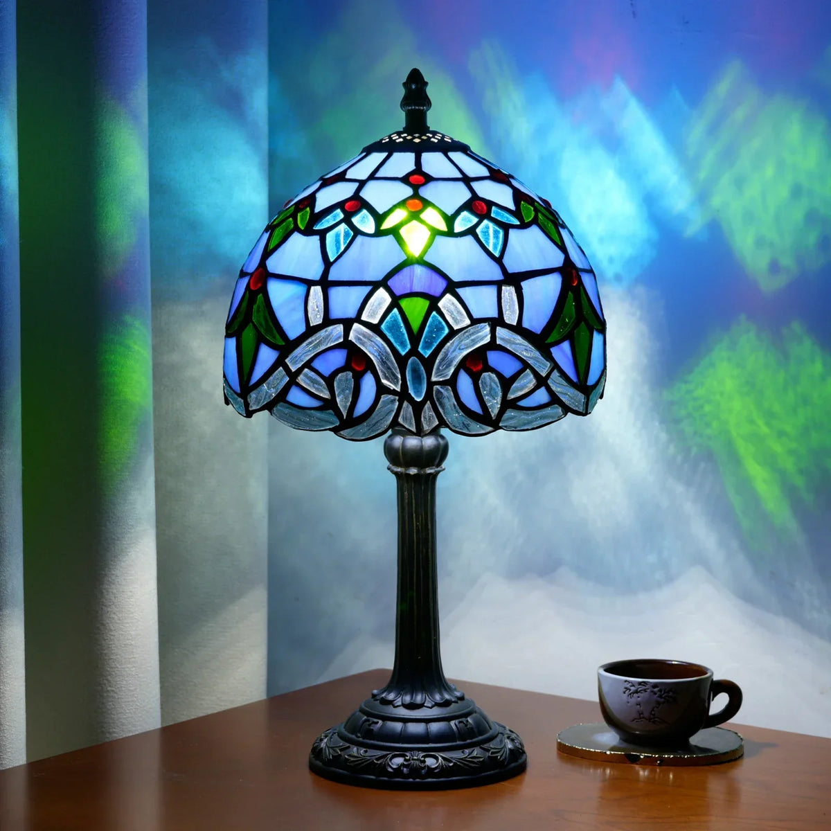 Lampada da tavolo in stile Tiffany con vetro colorato blu a motivi floreali.